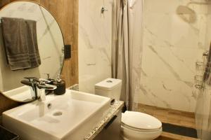 Un baño con lavabo, inodoro y espejo. en Brujas Tower- Hermoso departamento a pie de playa., en La Florida 39 fotos más