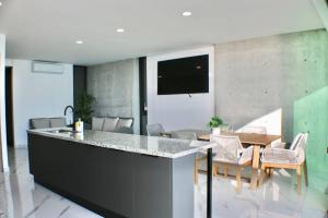 cocina y comedor con bar y mesa en Brujas Tower- Hermoso departamento a pie de playa., en La Florida