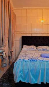 - une chambre avec un lit doté de draps bleus et une fenêtre dans l'établissement Casa kitnet, à Guarulhos