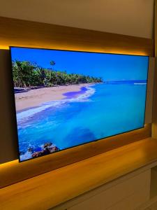 a television with a picture of a beach on it at Cute home 8 minutes to beach! in Melbourne