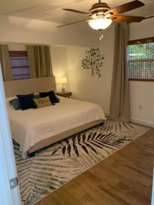 a bedroom with a bed and a ceiling fan at Cute home 8 minutes to beach! in Melbourne