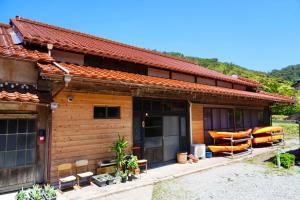a wooden house with orange kayaks on the porch at guesthouse碧 in Okinoshima
