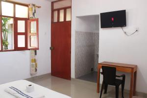 Habitación con mesa, silla y puerta en Casa Albina en Yurimaguas