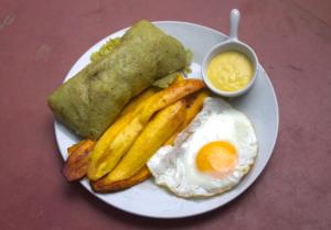un plato de comida con un huevo y papas fritas en Casa Albina en Yurimaguas