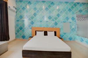 a bedroom with a bed and a blue wall at Super OYO The Royals Inn in Alīgarh