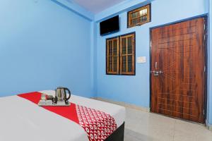 a room with a bed and a wooden door at OYO Flagship 70105 Hotel Pulick Awadh in Lucknow