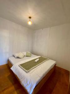 Un dormitorio con una cama con una manta verde. en Tribuana villa dieng en Wonosobo