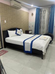 a bedroom with a large bed with blue curtains at hotel Hương Thiên Phú in Dĩ An