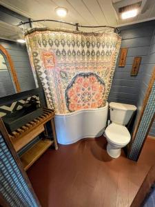 a bathroom with a toilet and a shower curtain at Breakers - stay in a tiny home on the Oregon Coast in Waldport