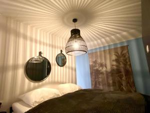 Schlafzimmer mit einer Decke, einem Bett und einem Spiegel in der Unterkunft Marina Strandbad Wellness-Chalet Romantik Haus Nr 411 in Olburgen