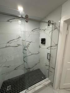 a bathroom with a shower with a glass door at Adrien Guest Studio in Miami Gardens