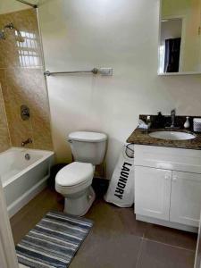 uma casa de banho com um WC, uma banheira e um lavatório. em BellaRose at Colbeck ,Gated with Pool, Stylishly modern em Old Harbour