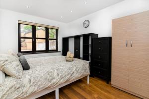1 dormitorio con cama y ventana grande en Modern House Just Refurbished, en Londres