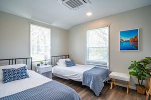 um quarto com 2 camas e 2 janelas em Renovated Retreat Home in Huron walking distance to beach em Huron