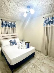 a bedroom with a white bed with blue and white curtains at Steps 2 Beach - 5 Bedroom 3 Bathroom Villa in Christ Church