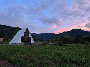 ein pyramidenförmiges Gebäude auf einem Feld mit Sonnenuntergang in der Unterkunft Ilusion Cabins La Florida in Pereira