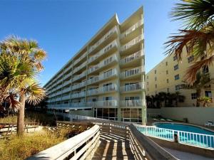 un gran edificio de apartamentos con piscina y palmeras en SC 601b - Bchfront -Free Seasonal Beach Service! en Fort Walton Beach