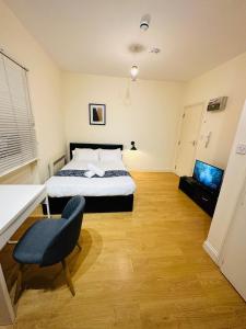 una camera con letto, scrivania e sedia di Chic Urban Retreat a Londra