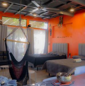 um quarto com duas camas e uma rede de descanso em Monkey garage en Orosi em Orosí