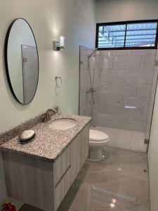 bagno con lavandino, servizi igienici e specchio di Monkey garage en Orosi a Orosí