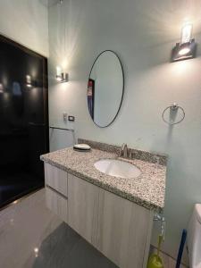 W łazience znajduje się umywalka i lustro. w obiekcie Monkey garage en Orosi w mieście Orosí