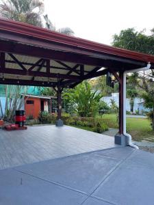 a pavilion with a red roof on a patio at Monkey garage en Orosi in Orosí