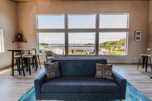a living room with a blue couch and a large window at Driftwood - Tiny Tranquility on the Oregon Coast in Waldport