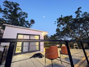 a cat laying on the deck of a house at The Retro Glass House in Mount Ābu