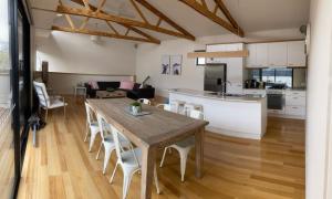 a kitchen and living room with a wooden table and chairs at Luxe Townhouse 2 Inlet Side Wifi in Inverloch
