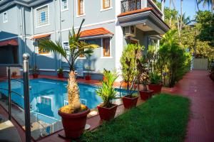 a house with a swimming pool and plants in front of it at Franria Villa Guest House in Calangute