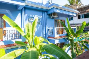una casa azul con plantas verdes delante de ella en Franria Villa Guest House en Calangute