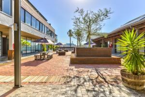 a patio with benches and tables in a building at Heritage Square Apartments in Durbanville