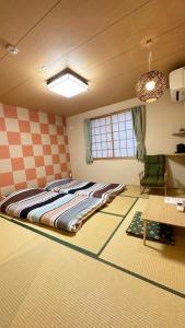 ein Schlafzimmer mit einem großen Bett in einem Zimmer in der Unterkunft Garden House Umenoya Otaru in Otaru