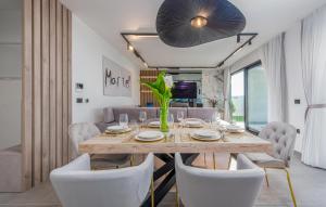 a dining room with a wooden table and white chairs at Gorgeous Home In Zadar in Zadar