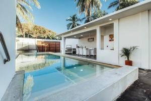uma piscina em frente a uma casa em New La Manzanilla Paradise Vibrant Pool Home em La Manzanilla