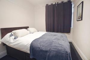 a bedroom with a bed with a blue blanket on it at October Disc - Long Stay - Contractors in Bristol