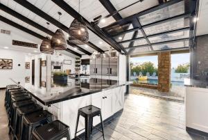 een keuken met een groot middeneiland met zwarte aanrechtbladen bij Luxury Pickleball - Concierge Service with Pool in Phoenix