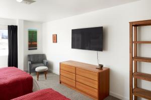 1 dormitorio con tocador y TV en la pared en Snob Hollow Inn Downtown Anchorage, en Anchorage