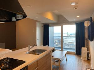 a kitchen with a sink and a large window at Stay`sOTARU in Otaru