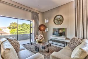 sala de estar con sofá y ventana grande en Heritage Square Apartments, en Durbanville