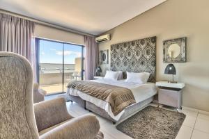 a hotel room with a bed and a balcony at Heritage Square Apartments in Durbanville