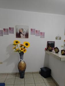 a vase with sunflowers in a room with pictures at MI HOGAR in Tegucigalpa