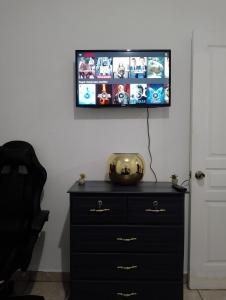 a black dresser with a television on a wall at MI HOGAR in Tegucigalpa