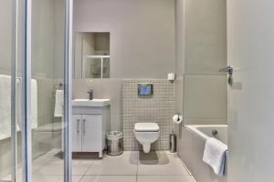 a small bathroom with a toilet and a sink at Heritage Square Apartments in Durbanville +75 photos