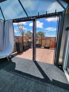 uma porta de vidro aberta de uma varanda com um pátio em Our Casetta em Richmond
