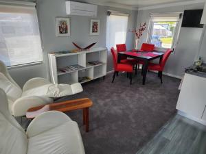 a living room with a table and red chairs at Our Casetta in Richmond