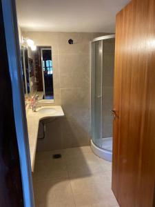 a bathroom with a shower and a sink and a mirror at Cabaña de Troncos in Oliveros