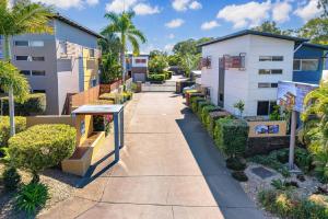 a sidewalk in front of a building with bushes at Quarterdecks Retreat in Hervey Bay