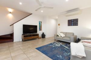 a living room with a flat screen tv and a couch at Pelcan Gardens Retreat in Broome