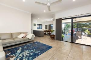 a living room with a couch and a dining room at Pelcan Gardens Retreat in Broome